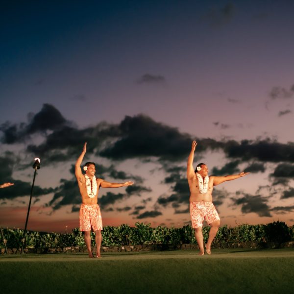 a group of people standing on top of a grass covered field